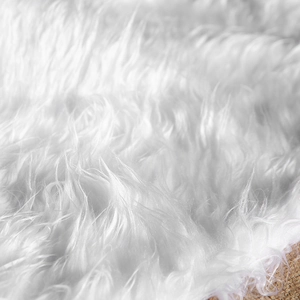 Close-up of soft white faux fur Christmas tree skirt texture on a wooden floor