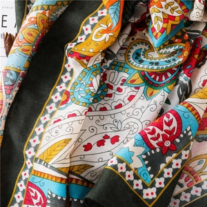 Détail de l'écharpe bohème à imprimé floral avec des motifs paisley et texture souple