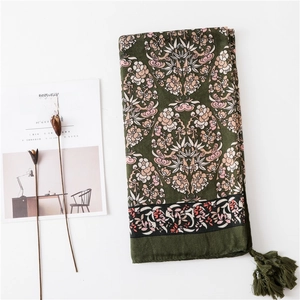 Détail du châle en coton et lin à imprimé floral avec des pompons et franges délicats