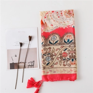 Vue détaillée du châle bohème à motif paisley avec pompons rouges et tissu léger imprimé