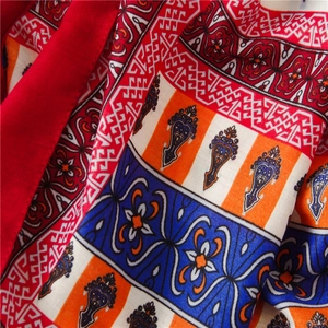 Gros plan sur un tissu à imprimé ethnique bohème avec des pompons et des motifs