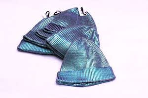 Macro detail of ribbed knit beanie with metallic teal laser coating texture