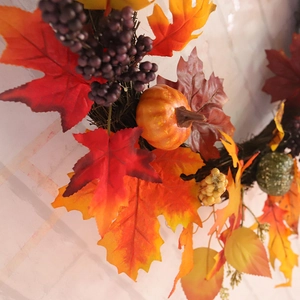Autumn maple leaf wreath with pumpkins and berries for Thanksgiving window decoration