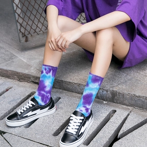 Unisex tie-dye crew socks in purple and blue gradient style worn by a model outdoors