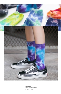 Detail of vibrant tie-dye crew socks paired with low-top sneakers on a street background