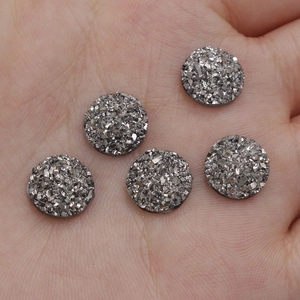 Macro shot of 10mm resin druzy cabochons held in hand for DIY jewelry making