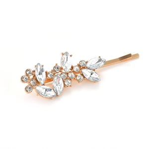 Eleganter goldener Haarclip in Blattform mit funkelnden Strasssteinen auf weißem Grund