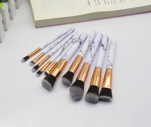 Detail of 10-piece marble makeup brush set with rose gold ferrules on a white background