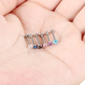 Macro detail of six stainless steel labret studs with square zircons in various colors