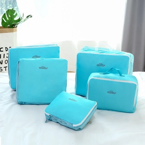 5-piece lake blue travel organizer bag set with mesh windows on a white bed