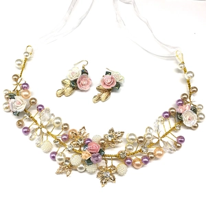 Detailed bridal hairpiece with floral ceramic elements and pearls in gold finish
