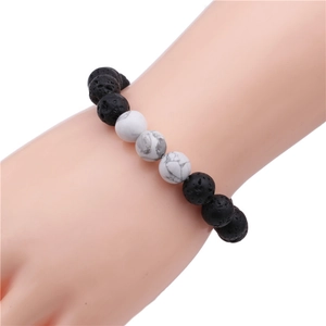 Close-up of 10mm lava rock and white turquoise beaded bracelet on a wrist