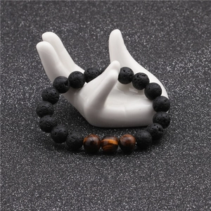 Detail of 10mm black lava stone and tiger eye beads on a white hand model display
