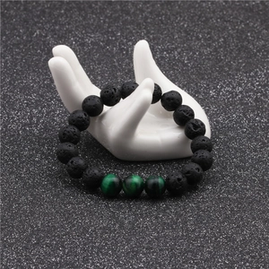 Detail showing 10mm black lava stone and green tiger eye beads on a hand model