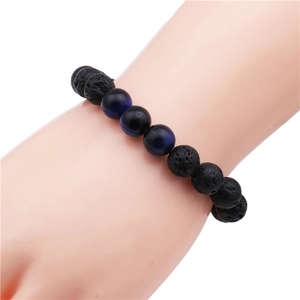 Detail view of 10mm black lava and blue tiger eye stone beaded bracelet on wrist