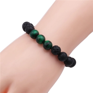 Close-up of 10mm black lava and green tiger eye stone beaded bracelet on wrist