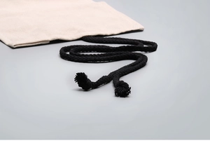 Close-up of beige canvas pencil roll with thick black braided rope for secure storage