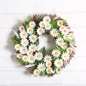 White daisy floral wreath with green leaves on natural vine base for wall decor