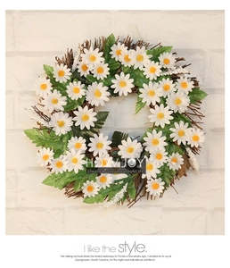 Detail view of a rustic daisy wreath with white petals and natural dried twig base