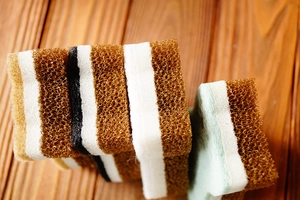 Macro detail of multi-layer cat-shaped sponge with fiber texture on dark wood background