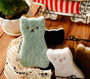 Detailed view of cat-shaped dish sponges in four colors placed in a white lace basket