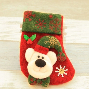 Detail of red and green Christmas stocking with 3D white bear and snowflake patterns