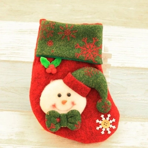 Detail of red Christmas stocking with snowman design and snowflakes on wooden background