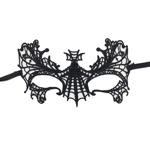 Close-up of black lace bat wing mask with intricate embroidery and silk ribbon ties