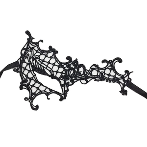 Detailed top view of black lace masquerade mask with intricate floral cutouts and silk ribbons