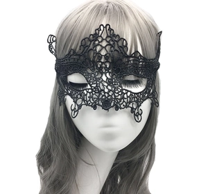 Detailed close-up of intricate hollow-out black lace masquerade mask on a model
