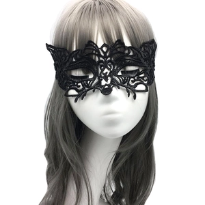 Close-up of intricate black lace masquerade mask with detailed hollow-out patterns
