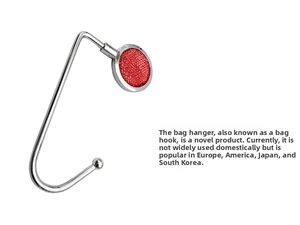 Detailed view of silver metal table hook featuring a vibrant red glitter decorative top