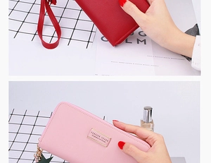 Detailed view of long women's wallet with wristlet, zipper and star charm detail