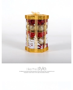 Detail of red and gold Christmas ornaments set in a hexagonal gift box with ribbon