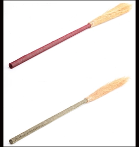 Vertical display of red and gold witch brooms with glittery handles for Halloween