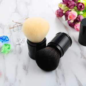 Macro detail of retractable makeup brushes with dual-color bristles on marble background