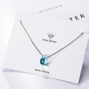 Elegant silver necklace featuring a translucent blue teardrop pendant on a fine chain