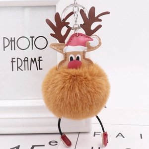Macro detail of Christmas reindeer plush ball keychain with leather antlers and hat