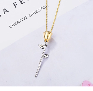 Detail of creative rose flower pendant necklace with gold and silver bicolor finish