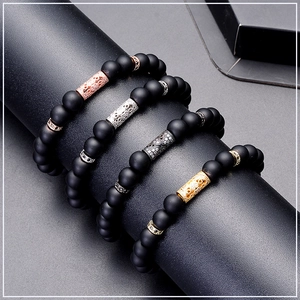 Detail of four matte black beaded bracelets with rose gold, silver, and gold metal tubes