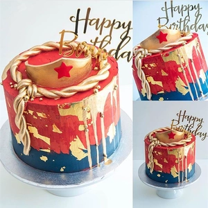 Wonder Woman themed birthday cake with gold crown topper and Happy Birthday acrylic sign
