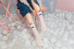 Detail of pink coral fleece socks featuring cute cartoon monster embroidery and grey ears