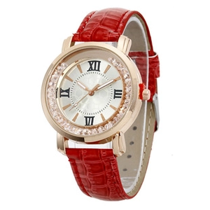 Detail of a rose gold watch with a red crocodile leather strap and rhinestone bezel