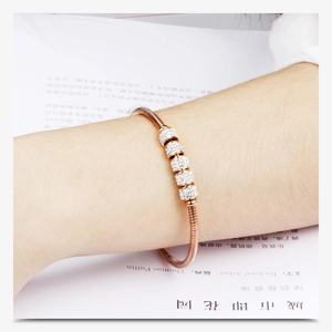 Detail of rose gold snake chain bracelet featuring five pave cubic zirconia slider beads
