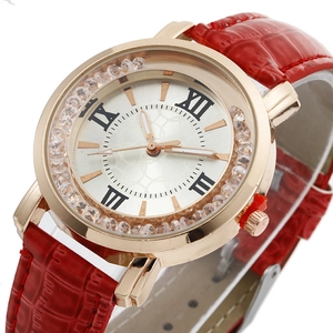 Detailed macro view of rhinestone studded gold watch case and red leather strap
