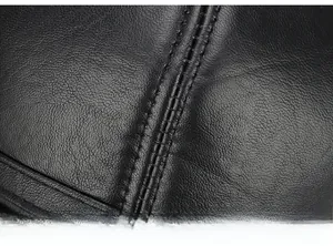 Close-up of black leather texture with detailed double stitching on baseball cap