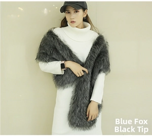 Detail of grey faux fox fur shawl with black tips on a white knit dress