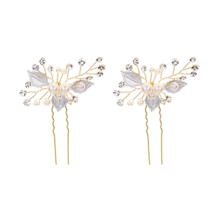 Detailed view of handmade bridal hair pins with white leaves and faux pearls