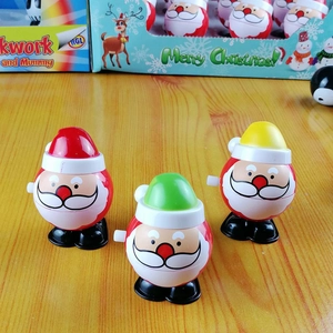 Detailed view of three colorful wind-up Santa toys in red, green, and yellow plastic