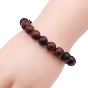 Detailed view of 10mm red spotted natural stone bead bracelet on a model hand